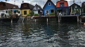 Una hilera de casas coloridas junto a un canal, con barcos amarrados al frente.