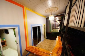 Ein Flur mit einer hölzernen Bank, einer Tür und einer Treppe, die zu einer anderen Ebene führt.