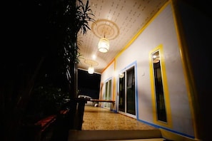 A hallway with a wooden floor, a bench, and a staircase leading to a door.