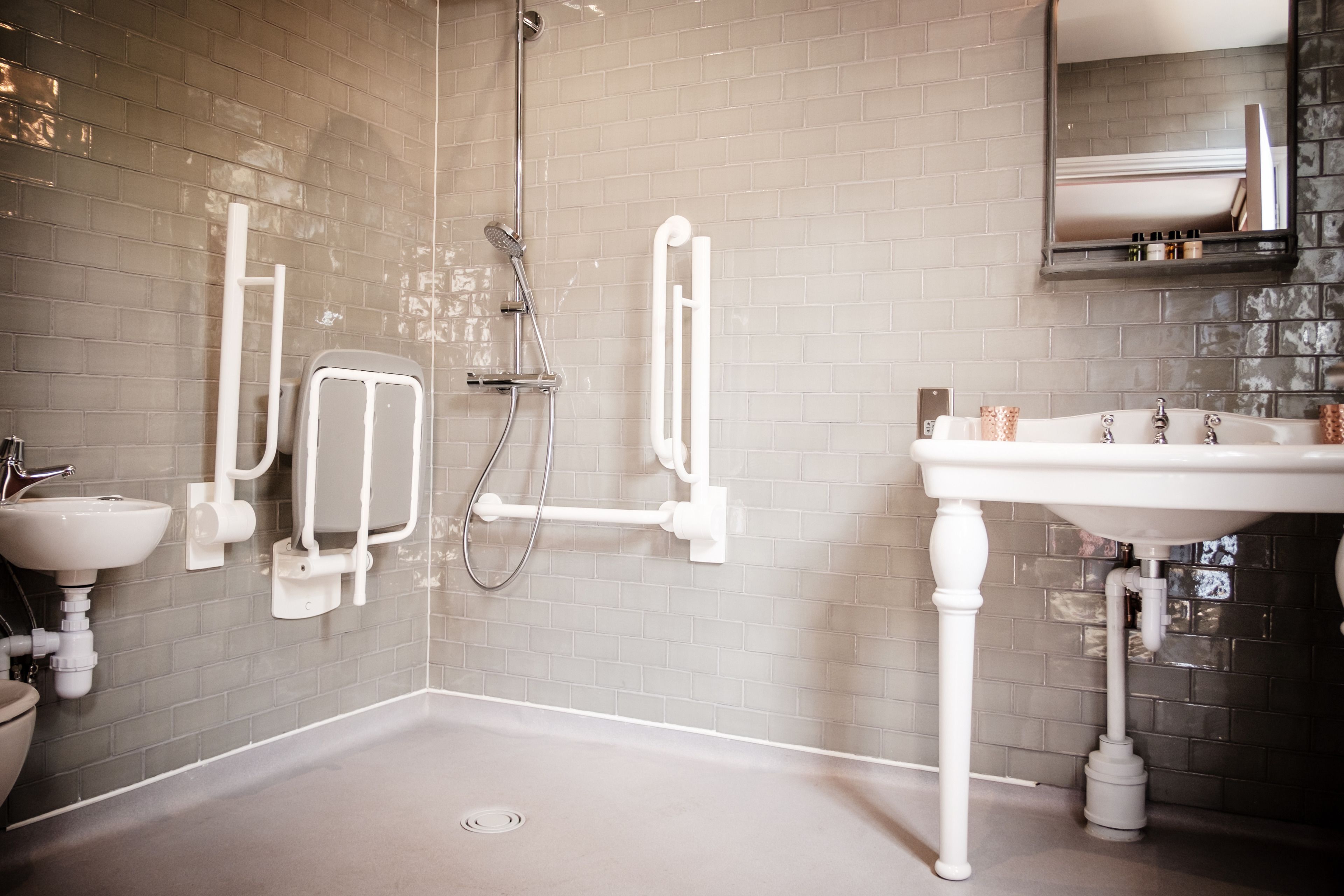 A modern bathroom with a shower, a sink, and a toilet.