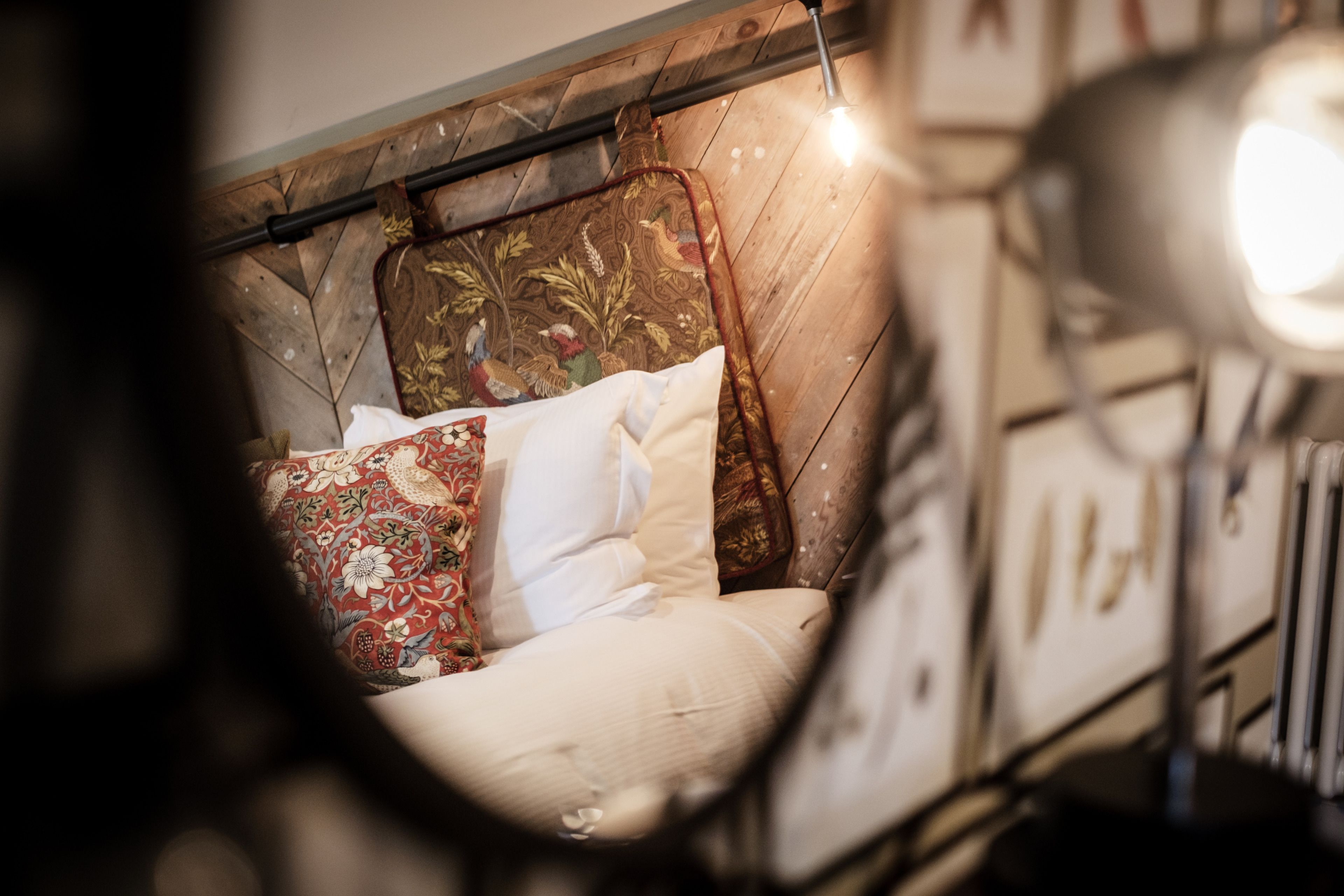 A bed with a wooden headboard and decorative pillows.