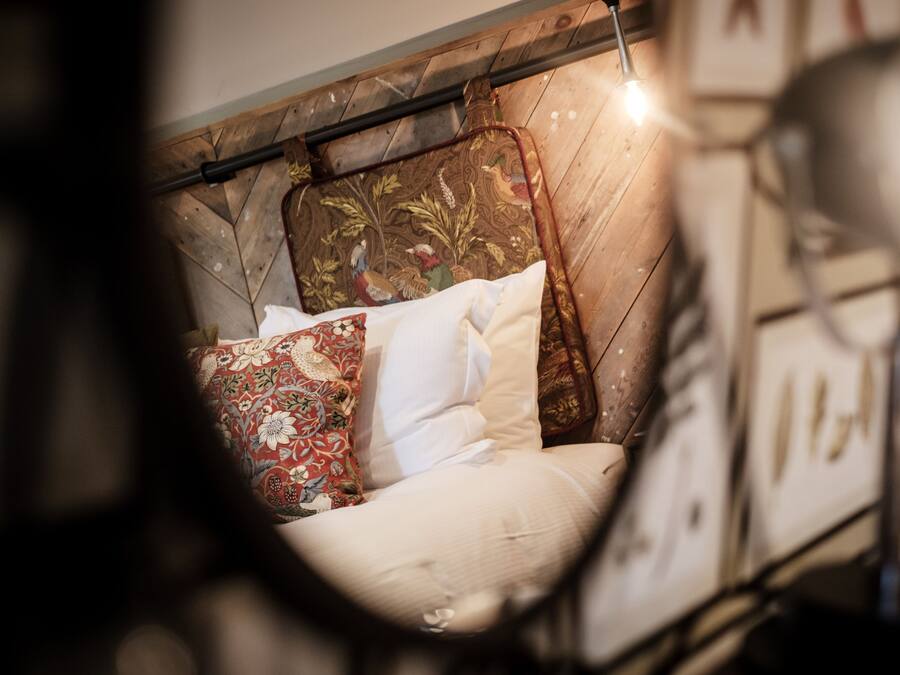 A bed with a wooden headboard and decorative pillows.
