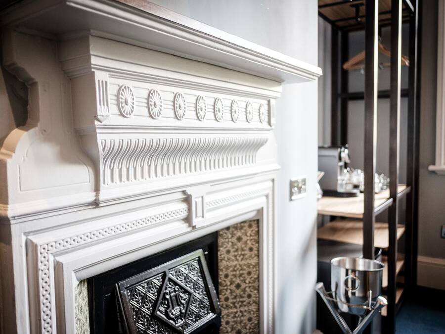 A white fireplace with intricate moldings and a decorative mantelpiece.