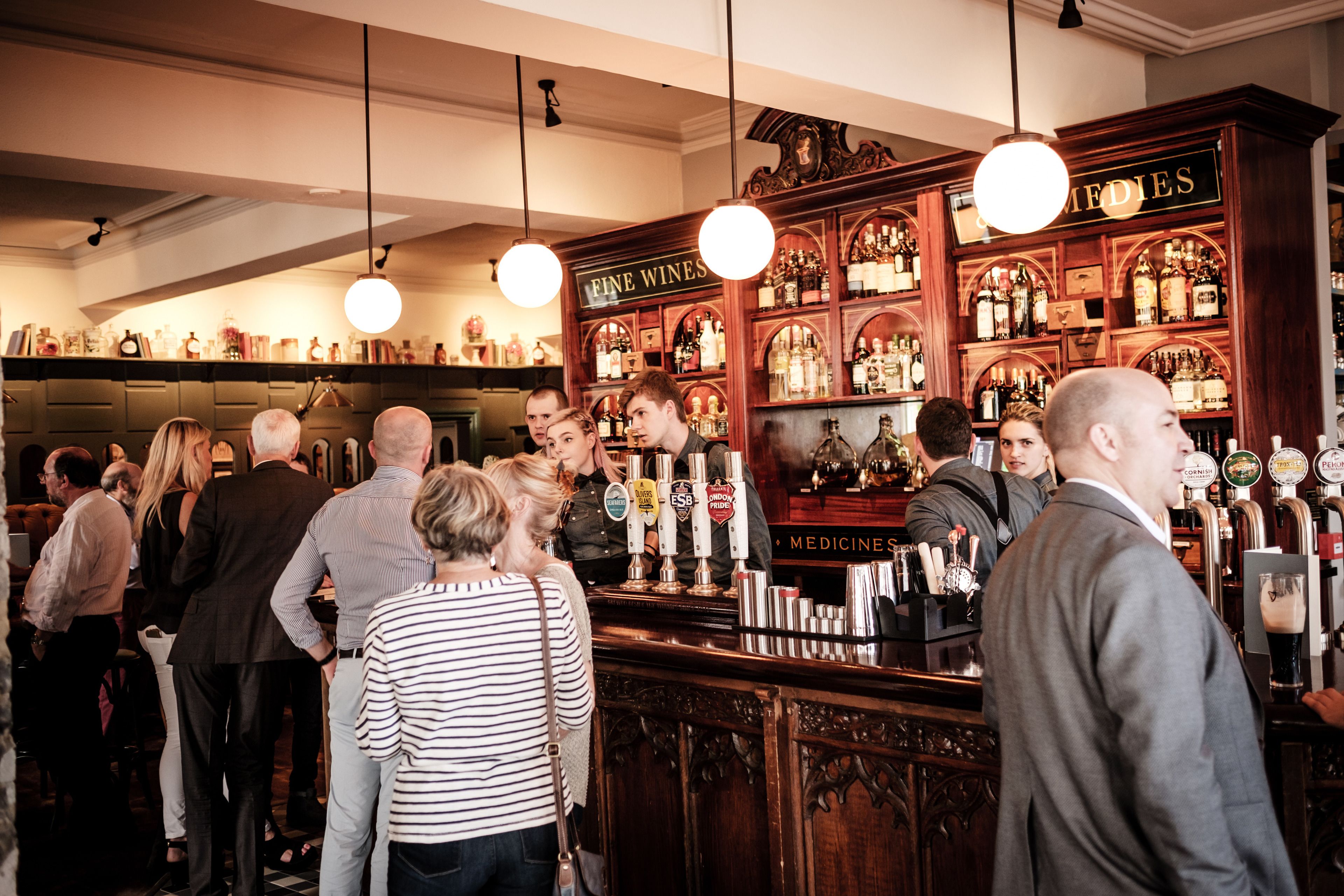 A bar with wooden shelves stocked with bottles and a sign reading "FINE WINES".