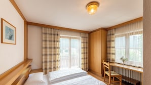 A bedroom with two beds, a wooden desk, and a chair. - Hotel Ristorante Walter (San Candido)