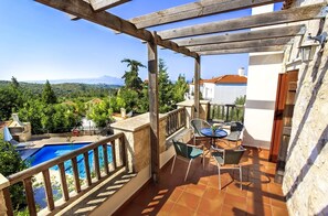 A terrace with a pool, outdoor seating, and a view of the surrounding landscape. - Douliana Villas (Apokoronas)
