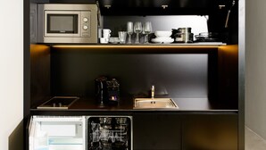 A compact kitchen with a built-in microwave, a sink, and a dishwasher.