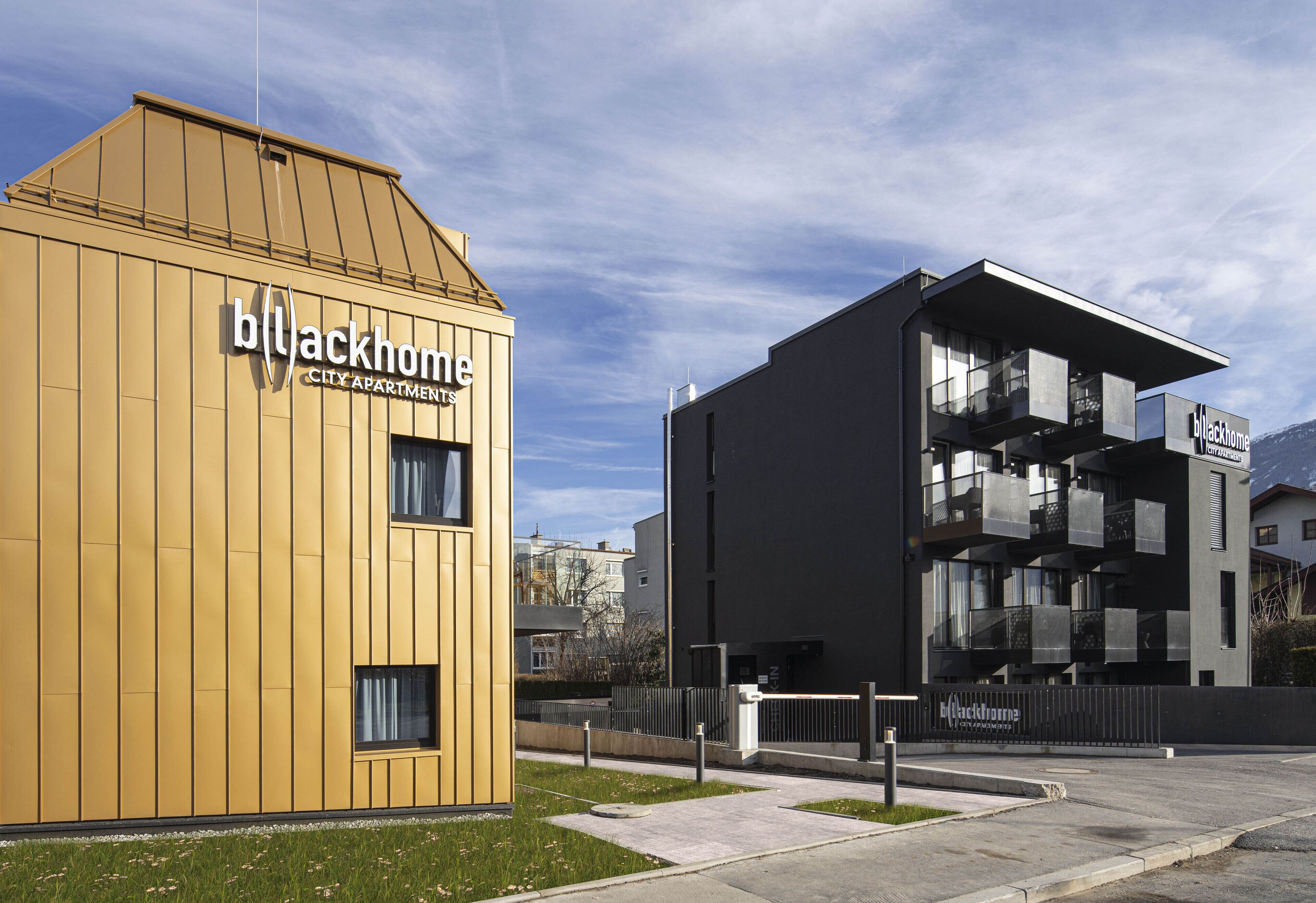 Two modern buildings with balconies, one labeled 'Blackhome City Apartments'.