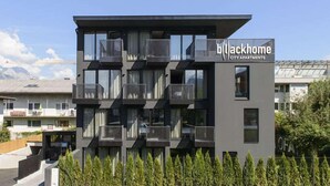A modern building with balconies and a sign reading "Blackhome City Apartments".