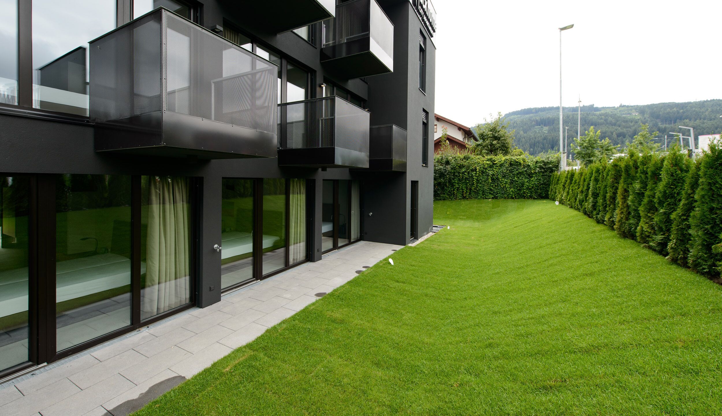 A modern building with large windows and a well-maintained lawn.