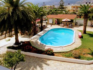 Alberca al aire libre, sombrillas en la alberca y camastros