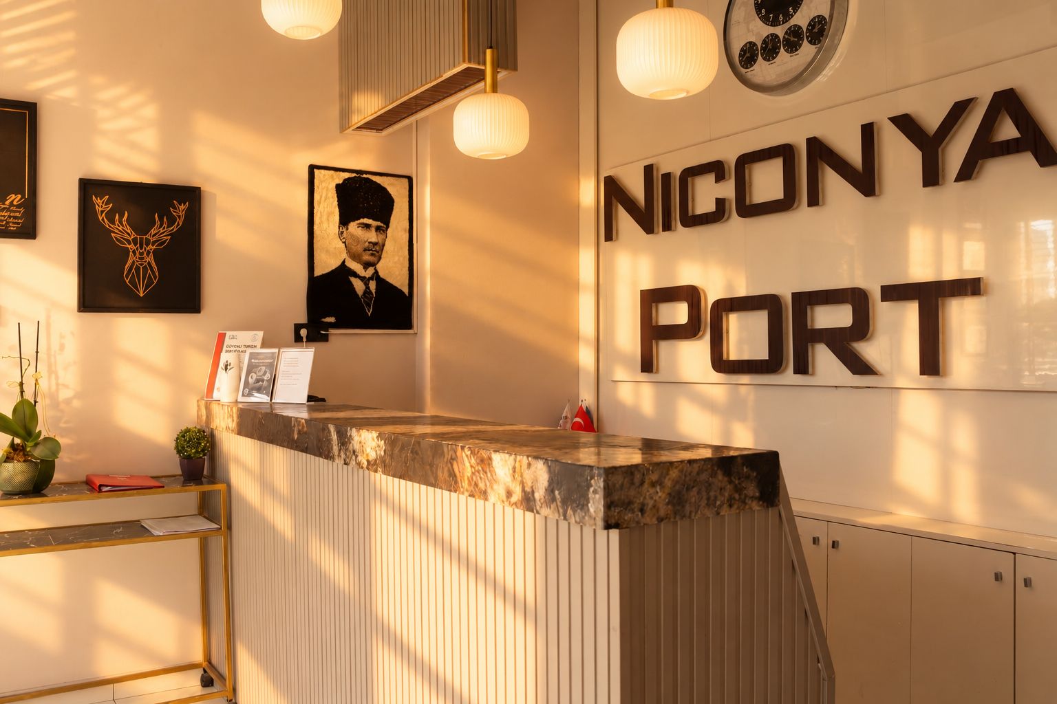 Un comptoir d’accueil avec un plateau en marbre, une horloge et des œuvres d’art encadrées accrochées au mur.