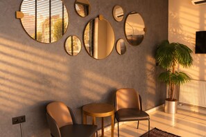 A modern interior with a seating area, wall-mounted mirrors, and a potted plant. - Niconya Port Suite&Hotel (Istanbul)
