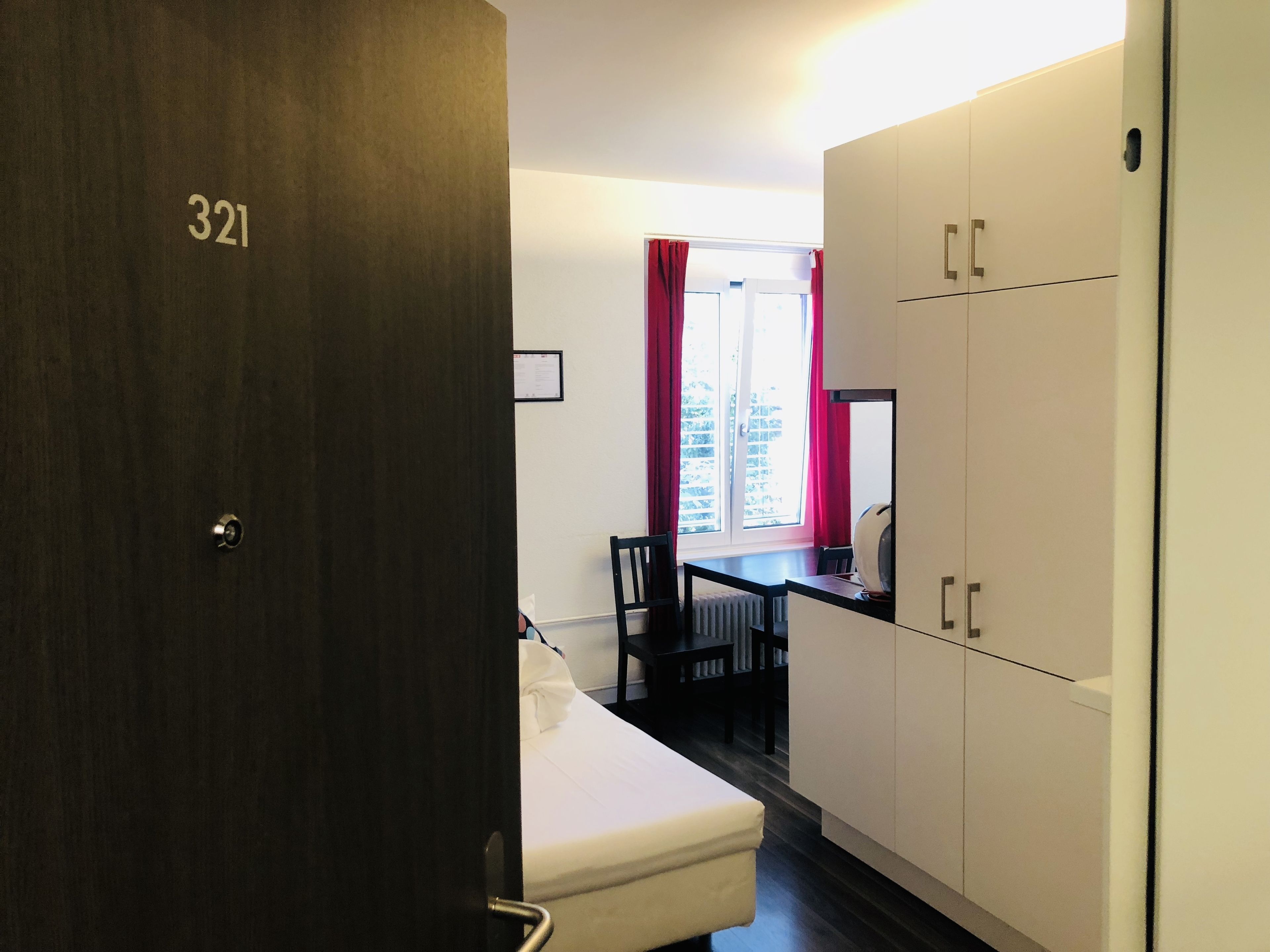 A room with a bed, a desk, and a wardrobe.