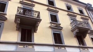 A multi-story building with balconies, a number '11' sign, and a window with a metal grate. - INSIDE FIVE City Apartments (Zürich)