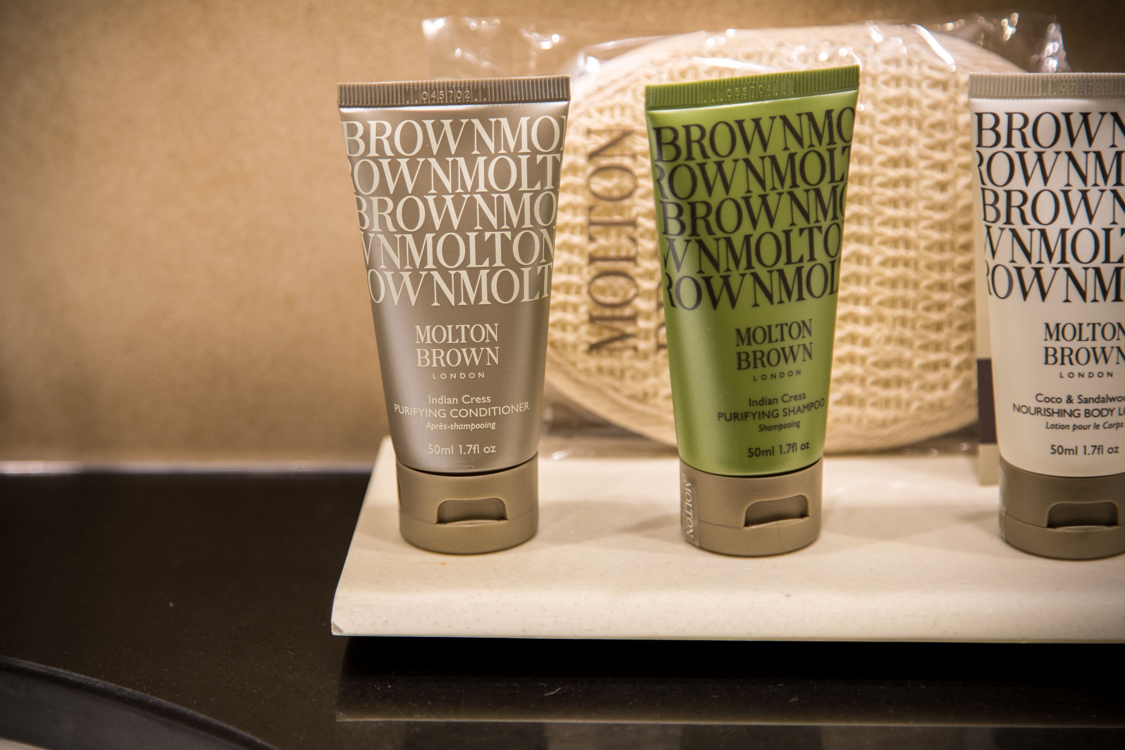 Drie flessen Brownmolt London shampoo op een witte ondergrond.