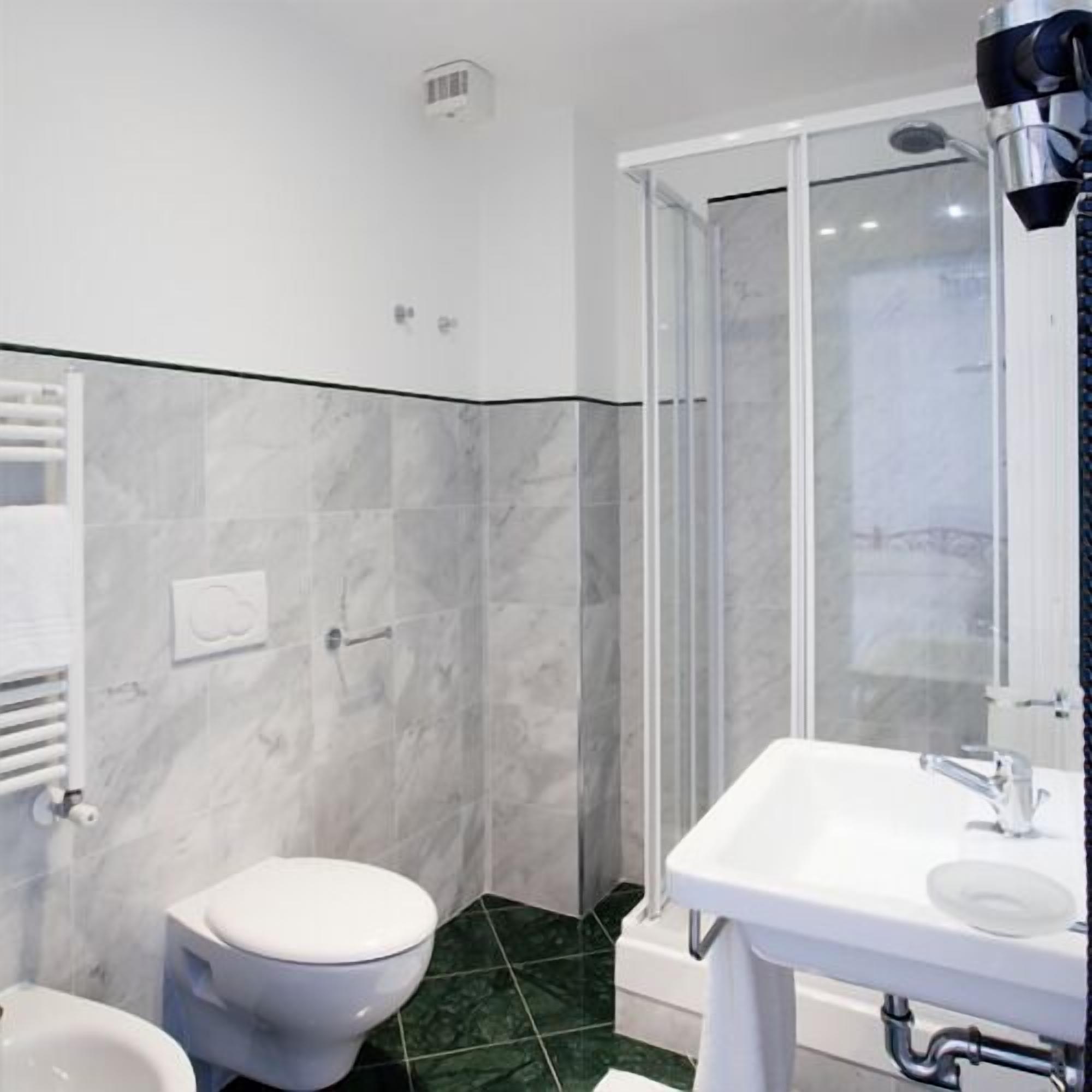 A bathroom with a toilet, bidet, and shower area.