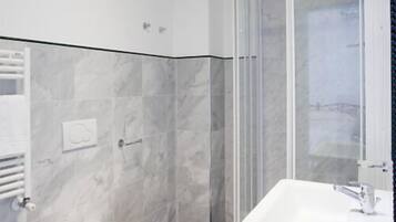A bathroom with a toilet, bidet, and shower area.