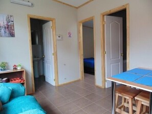 Departamento estándar, varias camas, para no fumadores (Familiar - 1 double bed + 2 sing. bed) | Área de sala de estar | Televisión de pantalla plana