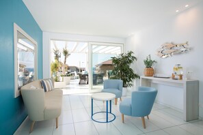 A modern living room with a sofa, two armchairs, a coffee table, and a large window with a view of the outside. - Hotel Blumarea, BW Signature Collection (Castelsardo)