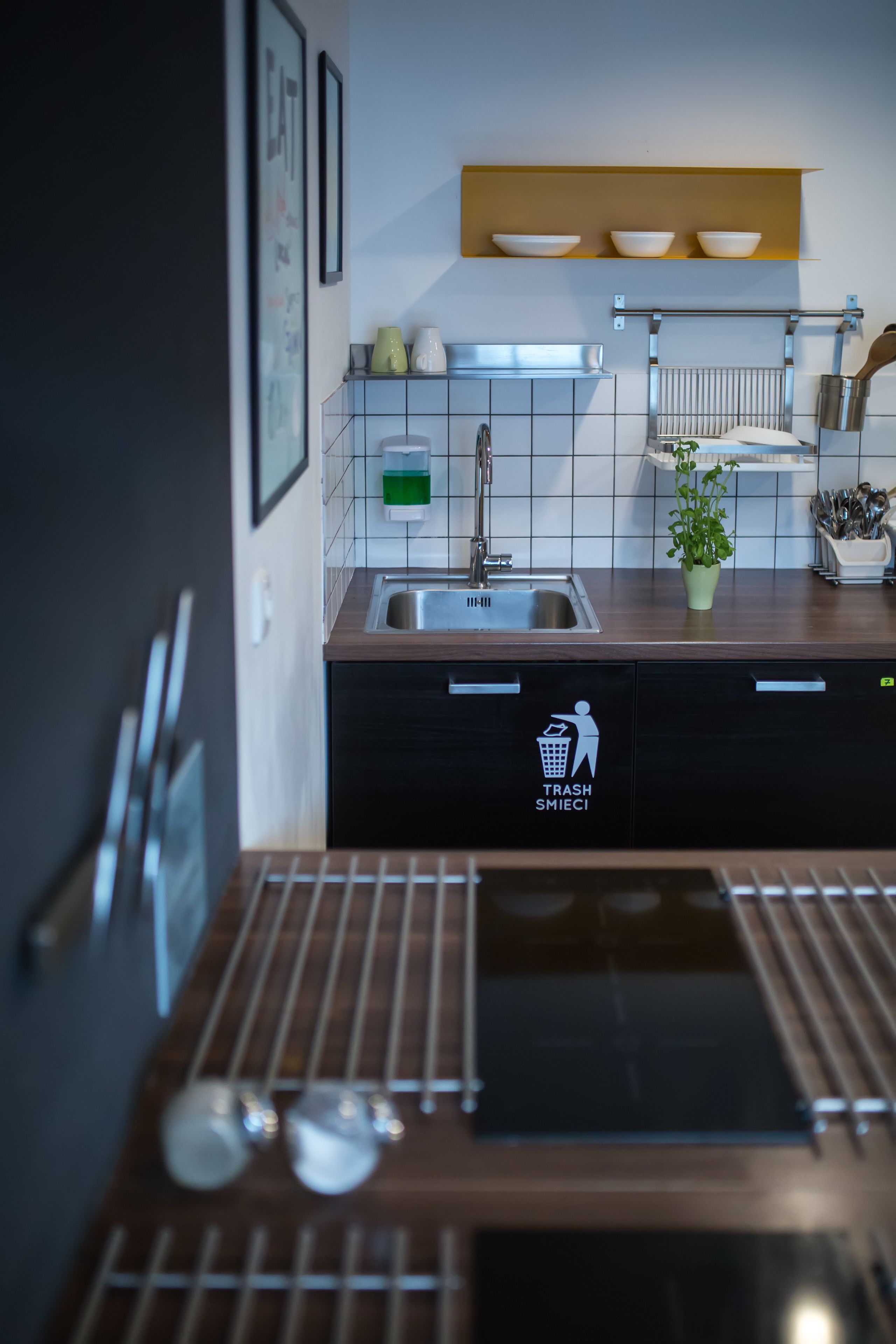 Une cuisine moderne équipée d’un évier, d’un plan de travail et d’une poubelle.