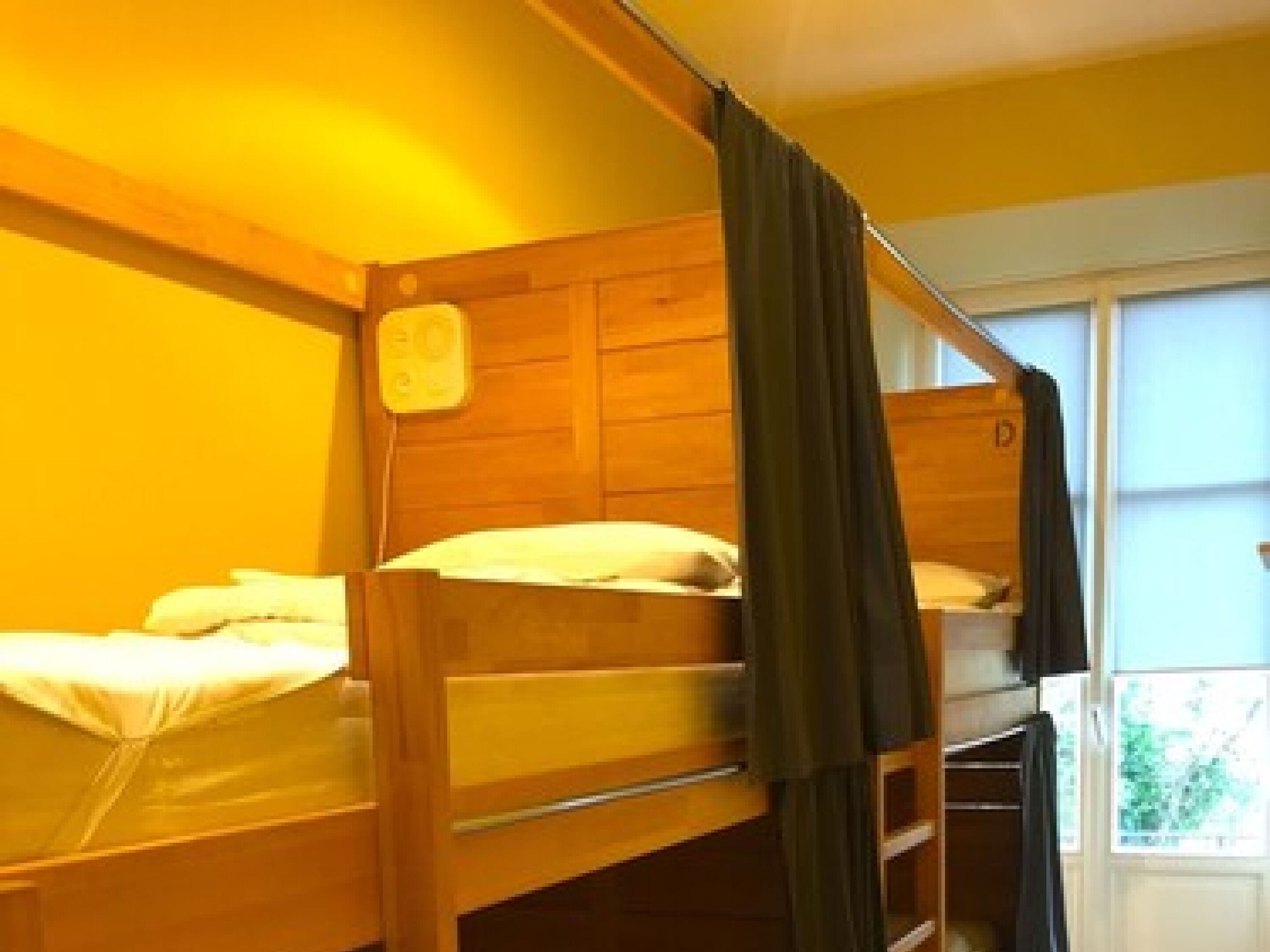A bunk bed room with wooden walls and a window.