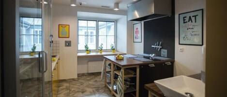 Una cocina moderna con un amplio ventanal, un lavamanos y una encimera.