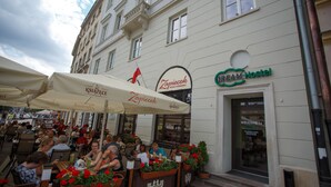 Un café con terraza, una bandera y un letrero de albergue.