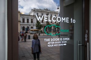 A welcome sign for a hostel with a view of a historic building in the background. - Safestay Warsaw Old Town (Warsaw)