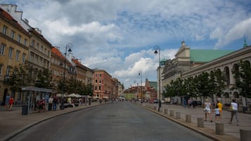 A wide, paved street lined with historic buildings, a clear sky, and pedestrians.