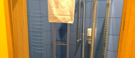A glass-enclosed shower stall with a towel hanging on the door handle.
