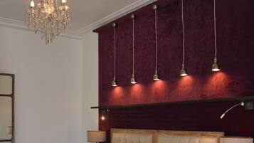 Une chambre à coucher avec un grand lit, un lustre et un mur d’accent de couleur rouge.