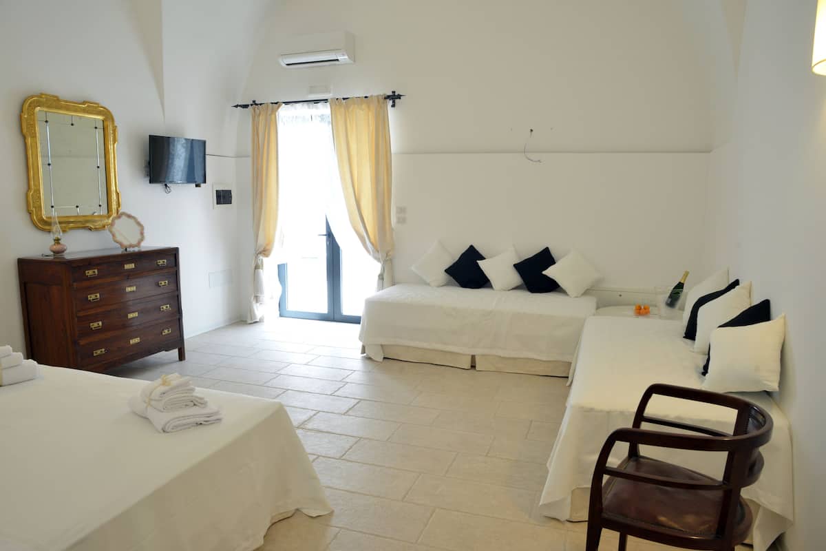 Habitación de hotel con dos camas, un tocador de madera, un televisor y una silla.