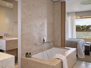 Un baño moderno con una bañera grande, ducha y tocador con espejo.