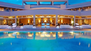 Un hotel moderno con piscina, zona de estar al aire libre y una entrada espaciosa.