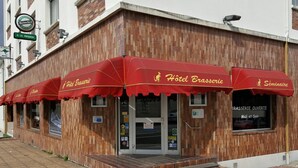 A wooden building with red awnings labeled "Hotel Brasserie" and "Séminaire." - Le Skippy (Saint-Pierre-des-Corps)