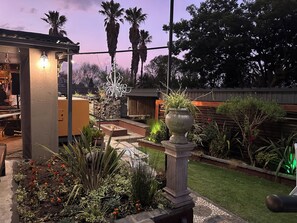 A garden with a pergola, a fire pit, and various plants. - Dara Guest House (Secunda)