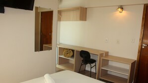 A bedroom with a bed, a desk, a chair, and a wardrobe. - Hotel Itajaí Tur (Itajai)