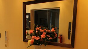 A bathroom vanity with a glass top and a vase of pink flowers. - White House Peru (Lima)