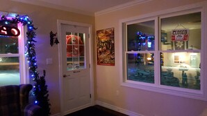 Un pasillo con una puerta cerrada, un árbol de Navidad y un cartel en la pared.
