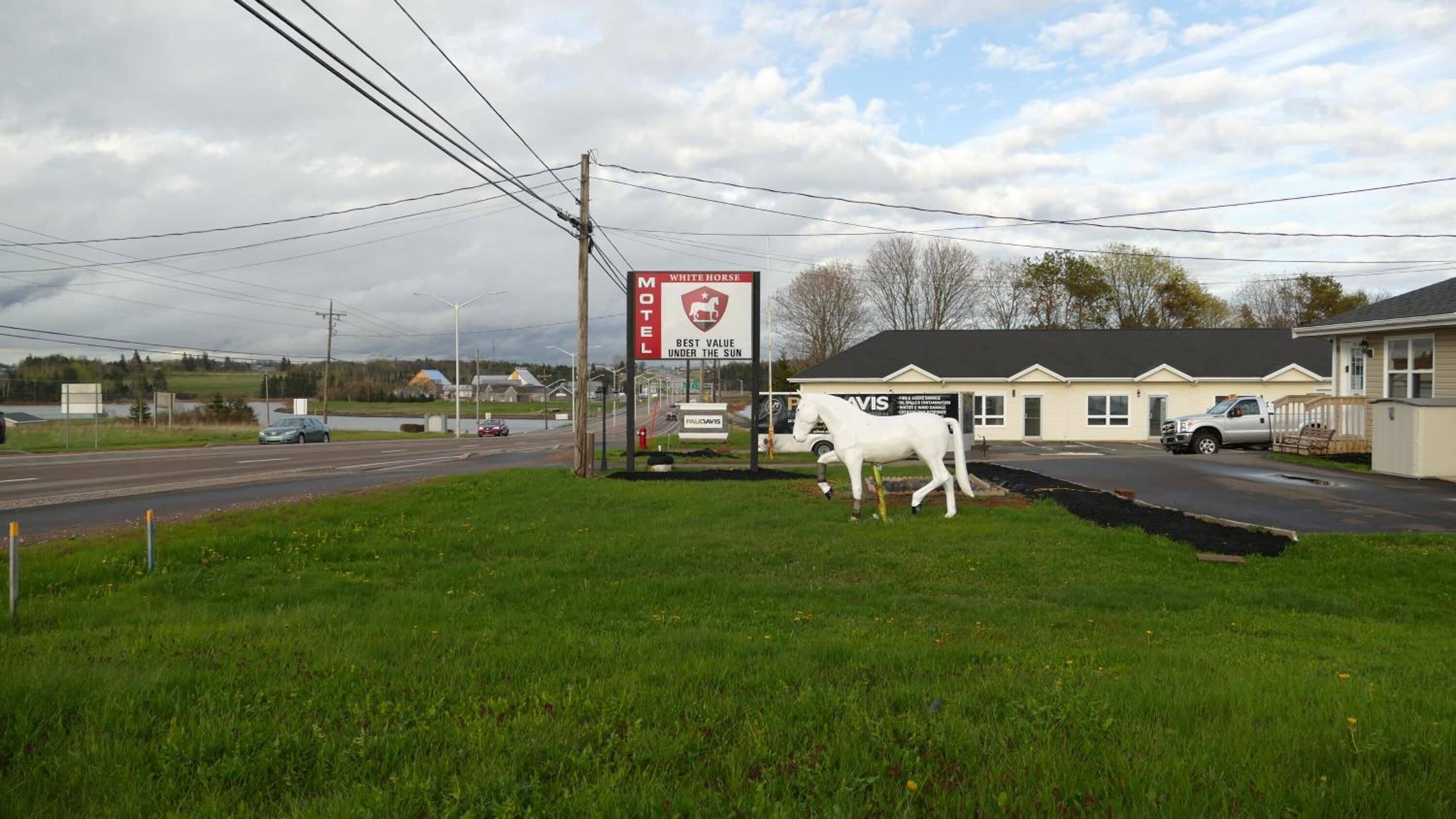 A motel with a large sign advertising 'White Horse' and 'Best Value Under the Sun'.