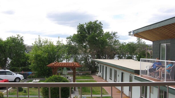 Ein Wohngebäude mit Balkon, überdachter Terrasse und Seeblick.