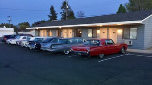 Un motel devant lequel s’étend une rangée de voitures anciennes garées.