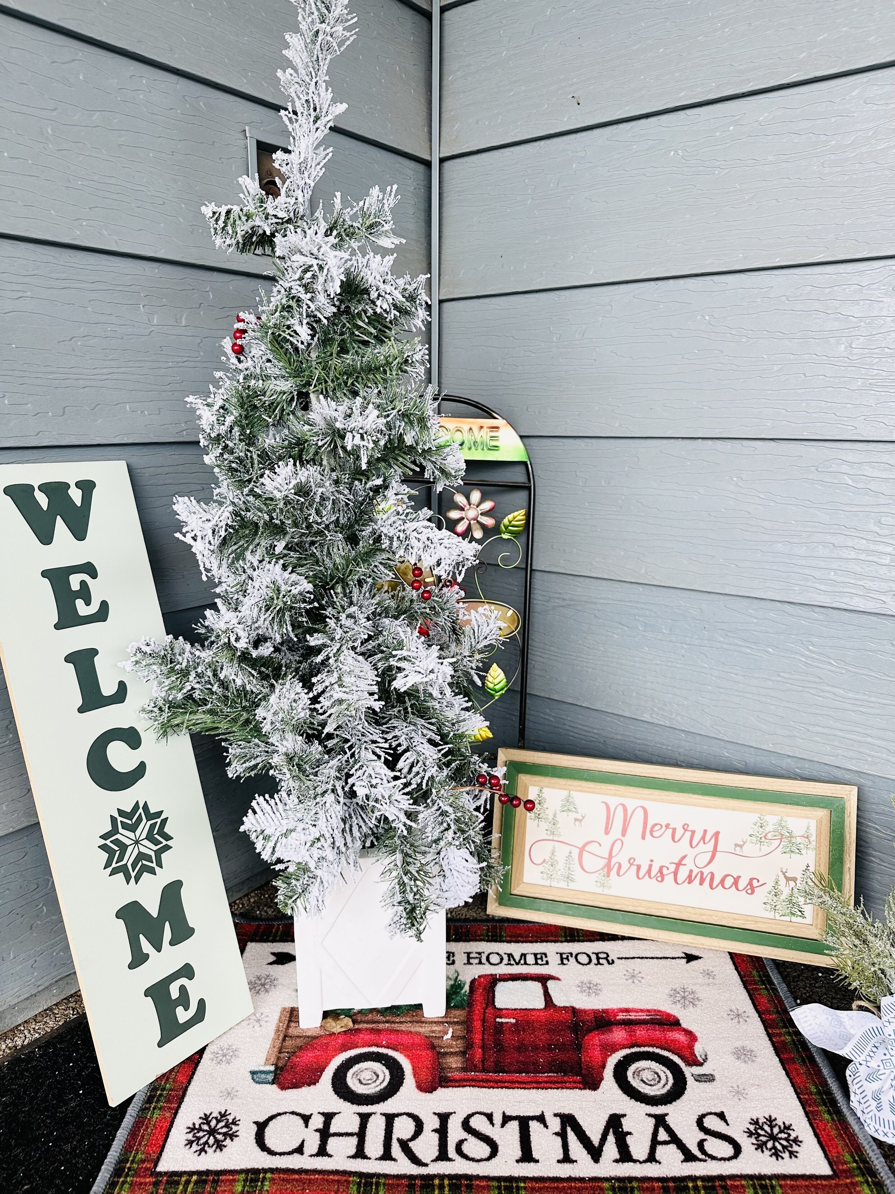 En pyntet juletræ med et 'WELCOME'-skilt og et 'God Jul'-skilt.