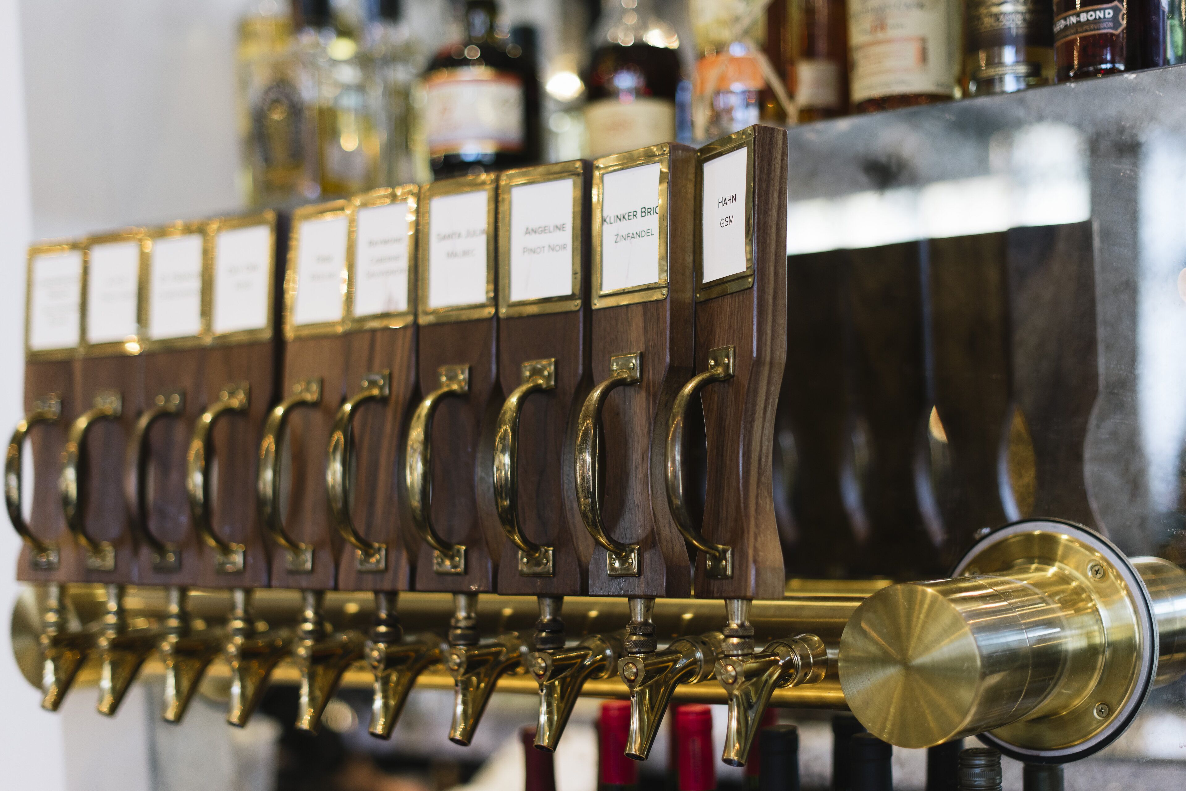 A row of beer taps with labels, each indicating a different type of beer.