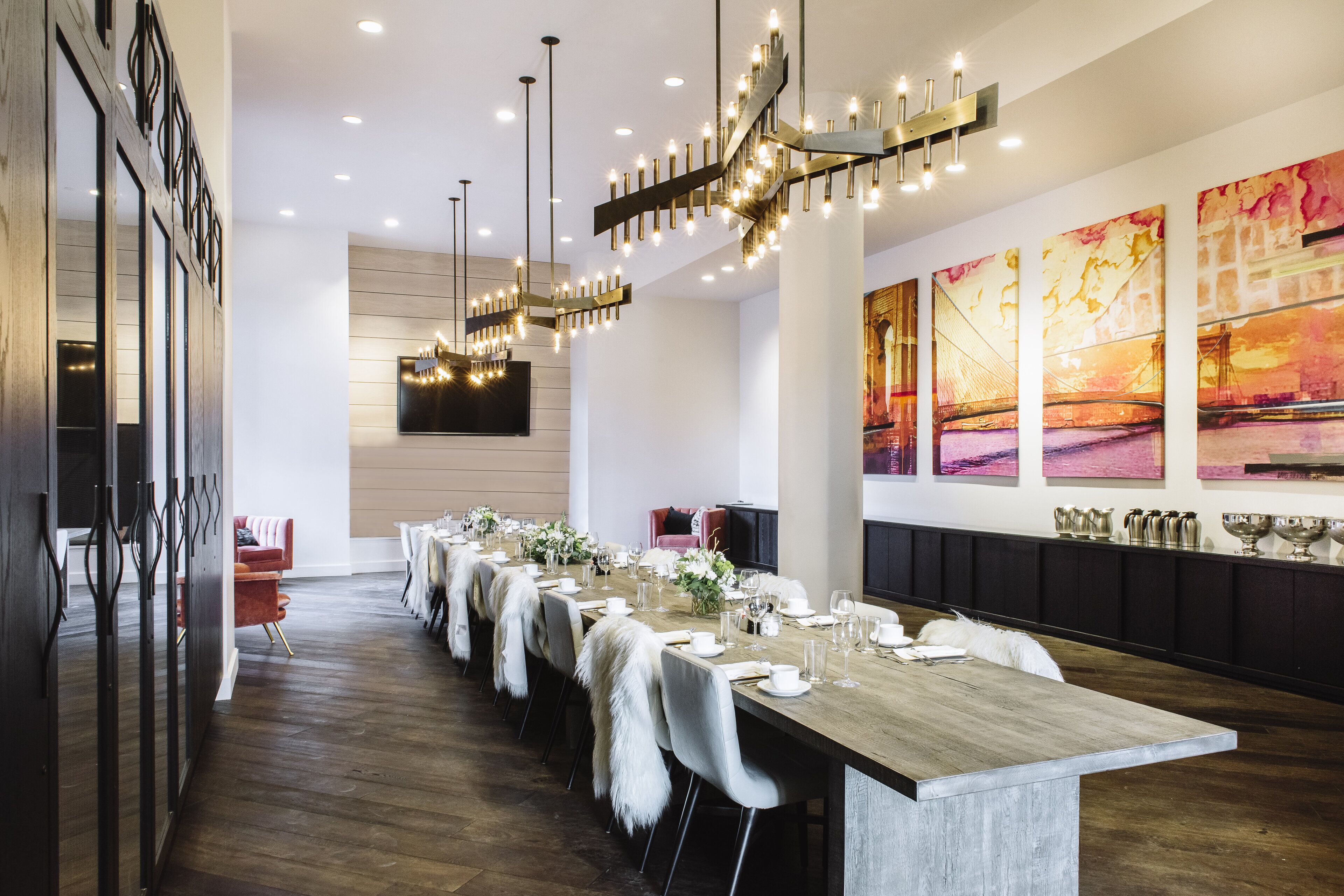 Una larga mesa de comedor dispuesta con manteles blancos, sillas y centros de mesa.