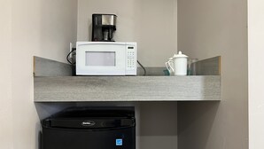 A compact kitchenette with a microwave, coffee maker, and a small refrigerator. - Kluane Park Inn (Haines Junction)