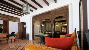 A traditional interior with a sofa, wooden furniture, and a patterned floor. - Jawi Peranakan Mansion (George Town)