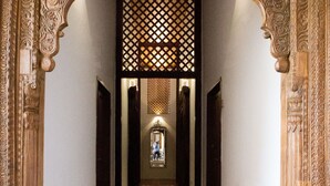 A hallway with ornate wooden arches and a patterned carpet. - Jawi Peranakan Mansion (George Town)