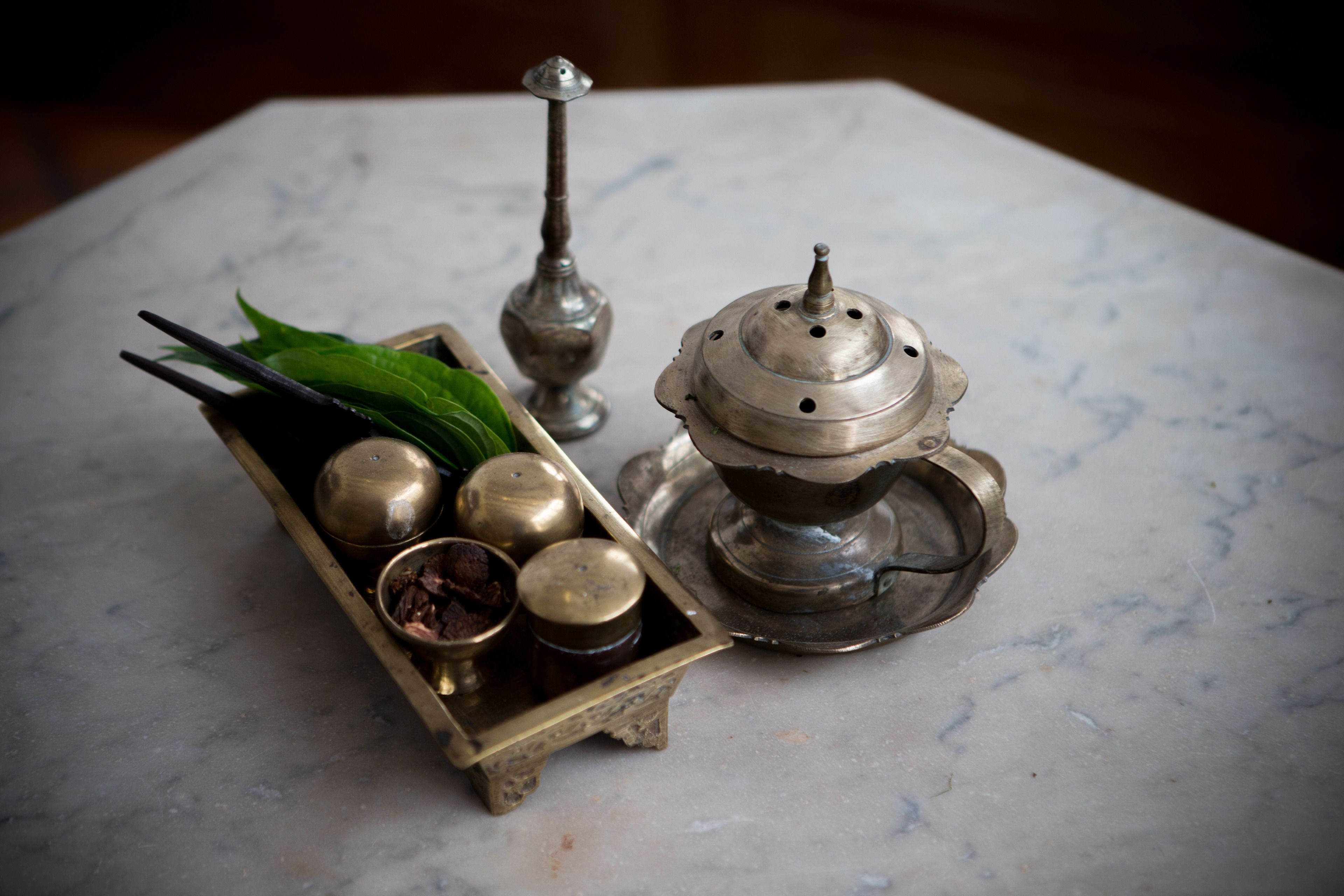 Una bandeja de bronce con un juego de té sobre una mesa de mármol.